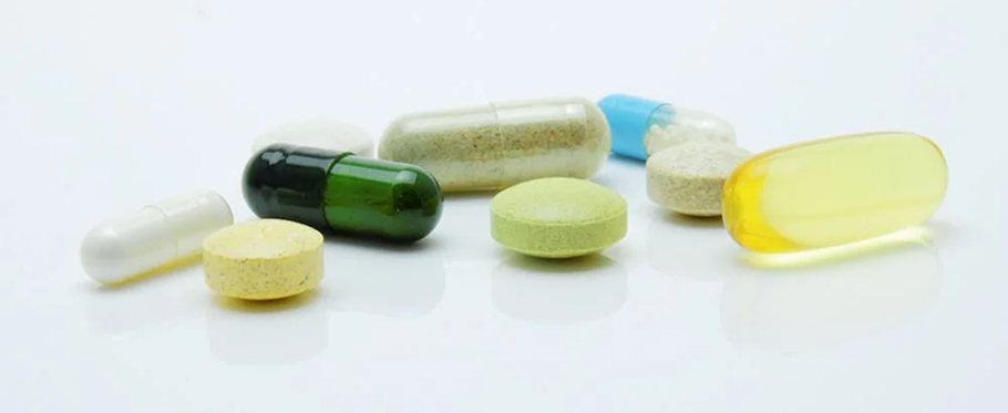 Assorted colorful pills and capsules on a white background