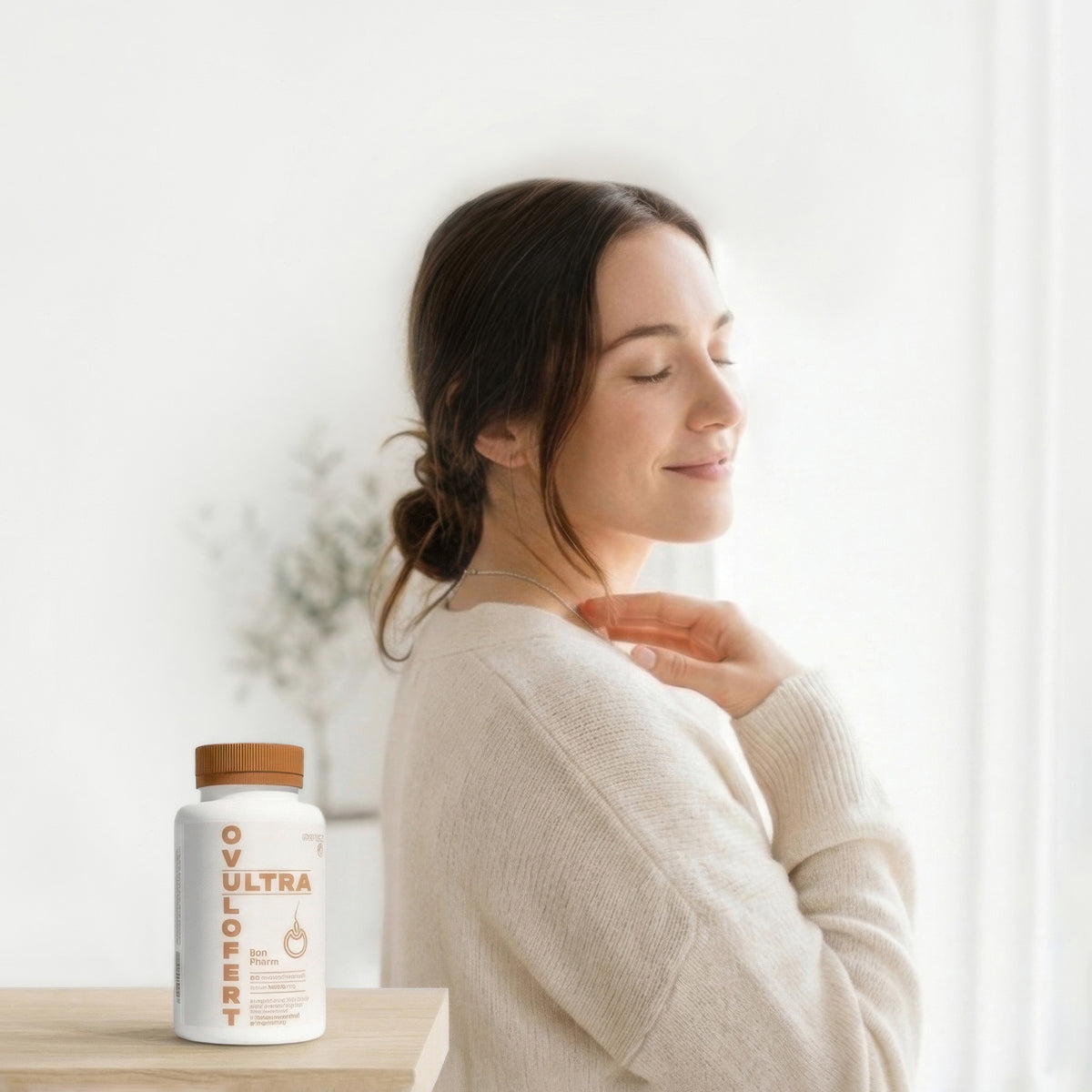 Woman with a bottle of Ovulofert on a table, with a blurred background